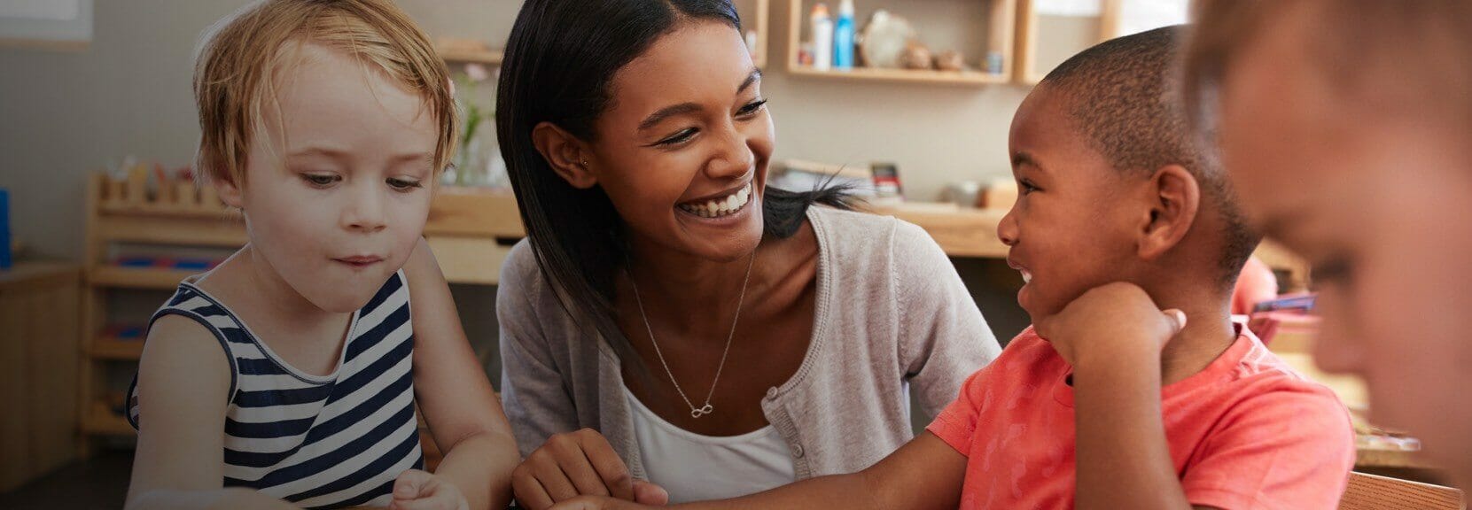 Early childhood education instructor teaching a group of three children.