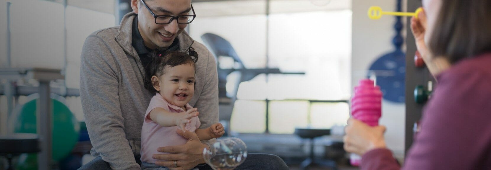 Occupational therapist blowing bubbles at work with a patient who is a baby.