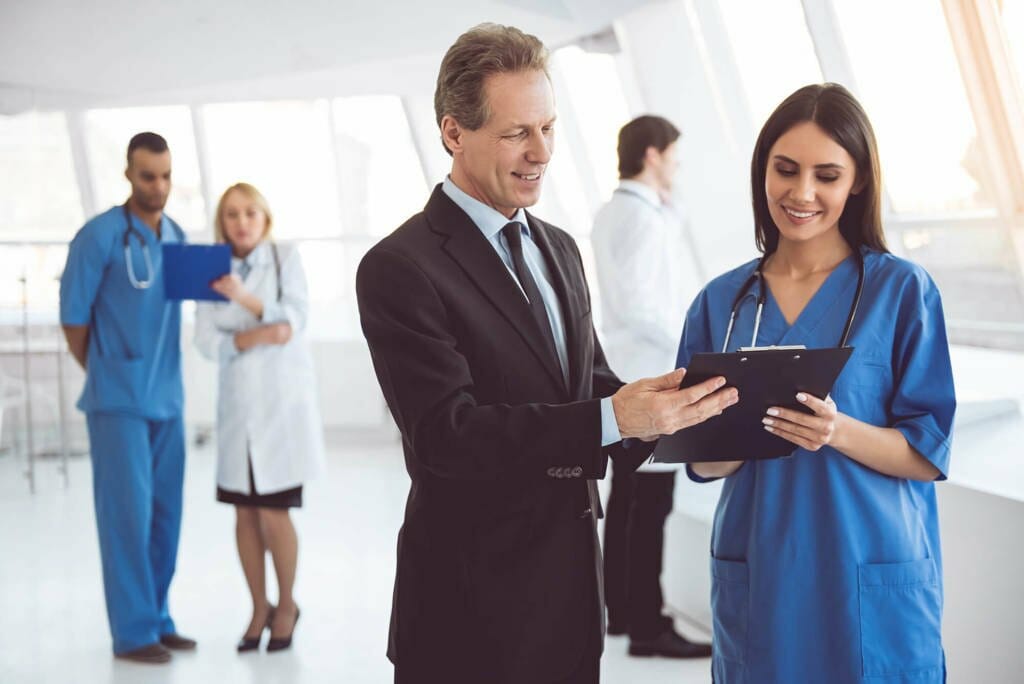 Man with Female Doctor viewing clipboard