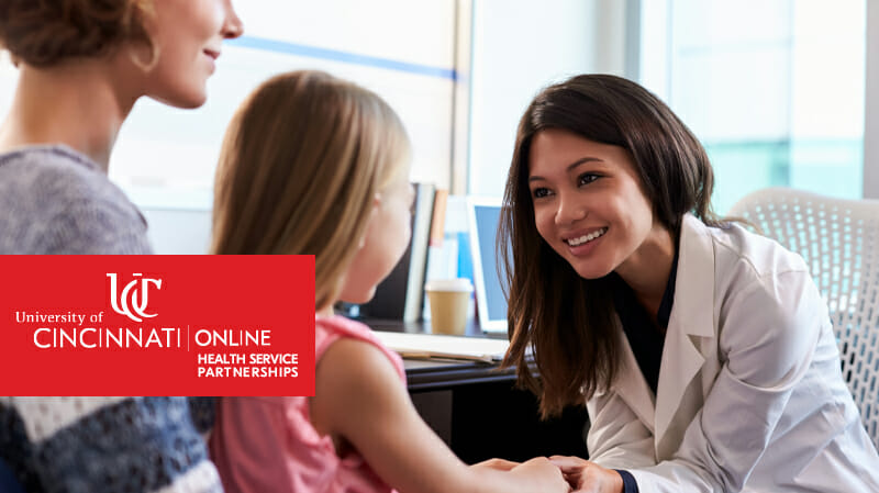 Smiling health professional holding hands of little girl