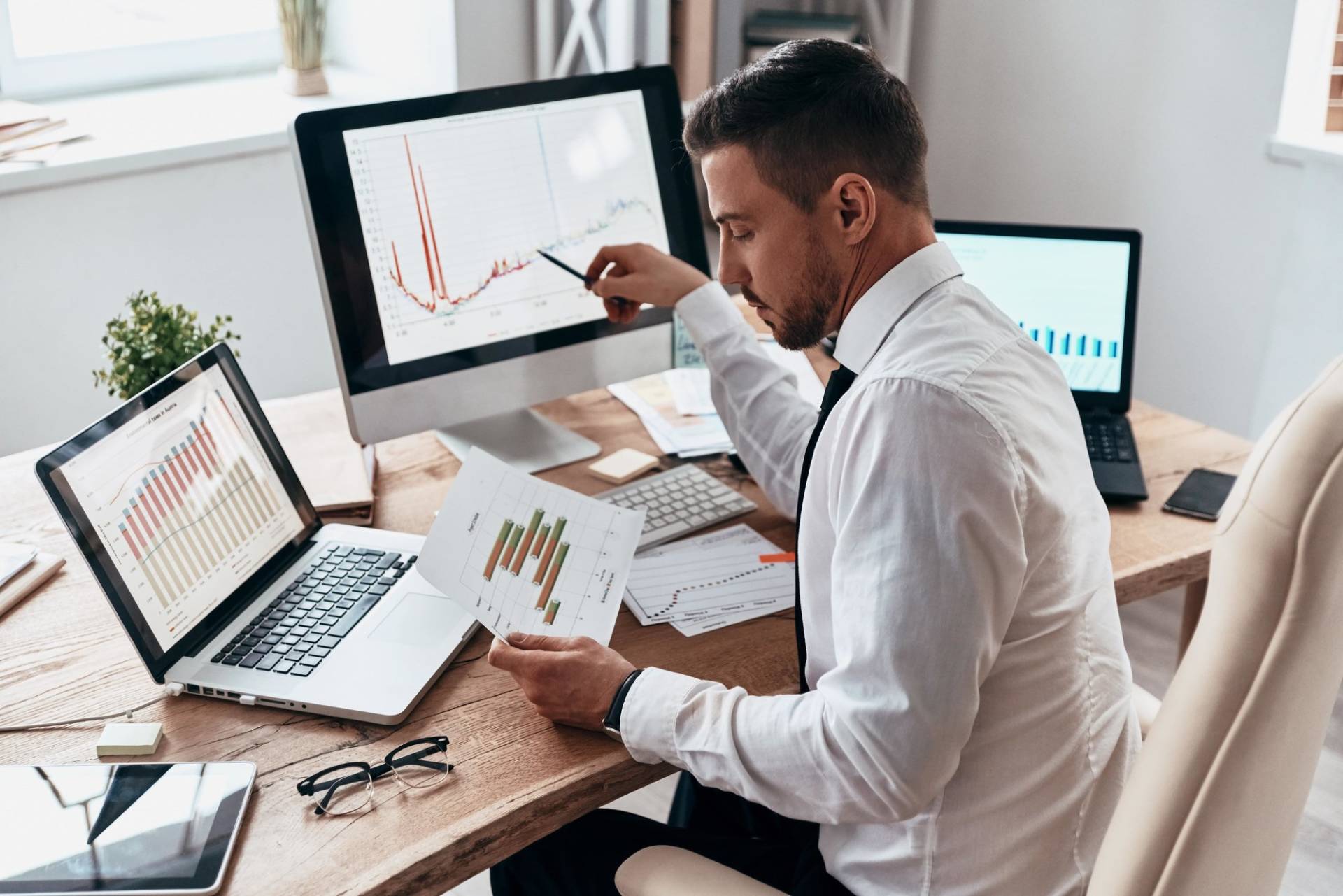 Man working on laptop with graphs