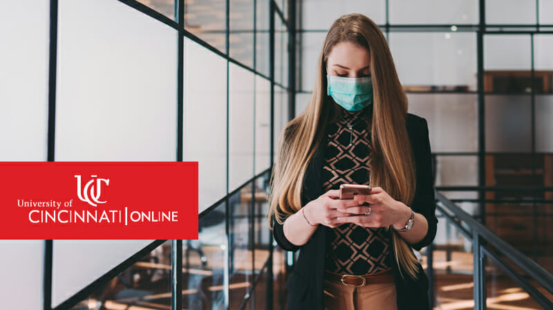 Woman, wearing a facemask, texting