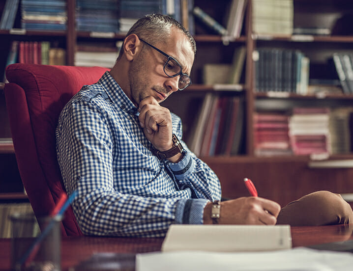 man writing on paper