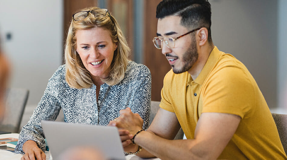 two people looking at a laptop