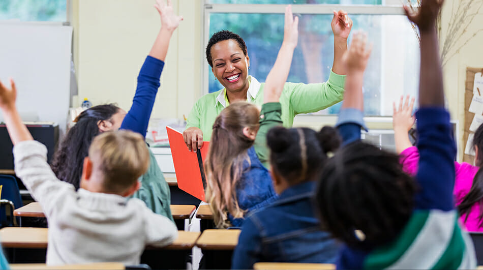 students and teacher raising their hands