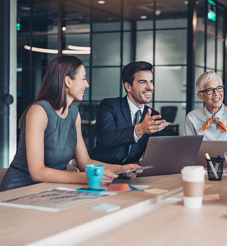Three people sitting at table talking
