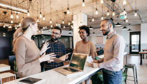 Female business manager talking to employees| The University of Cincinnati Online.