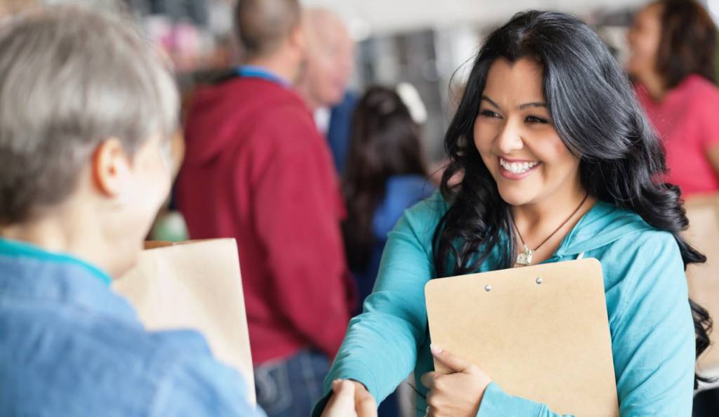 Social Worker greeting an adult with a handshake.