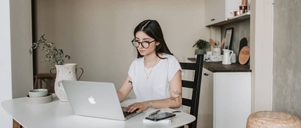 Female student studying with a laptop and earbuds