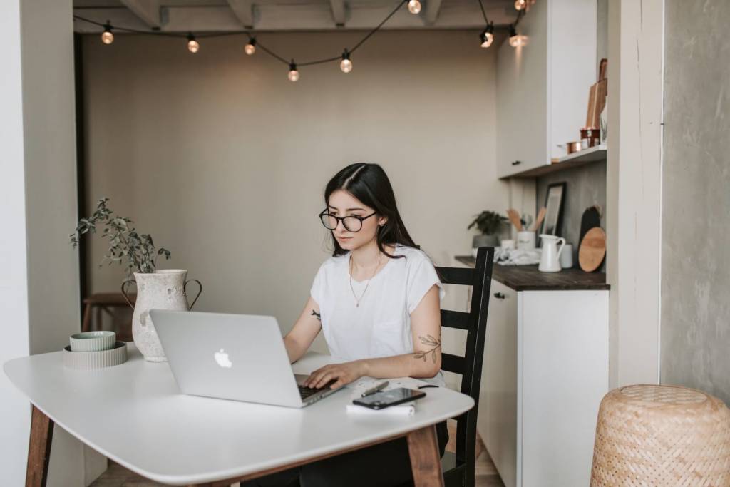 Female student studying with a laptop and earbuds