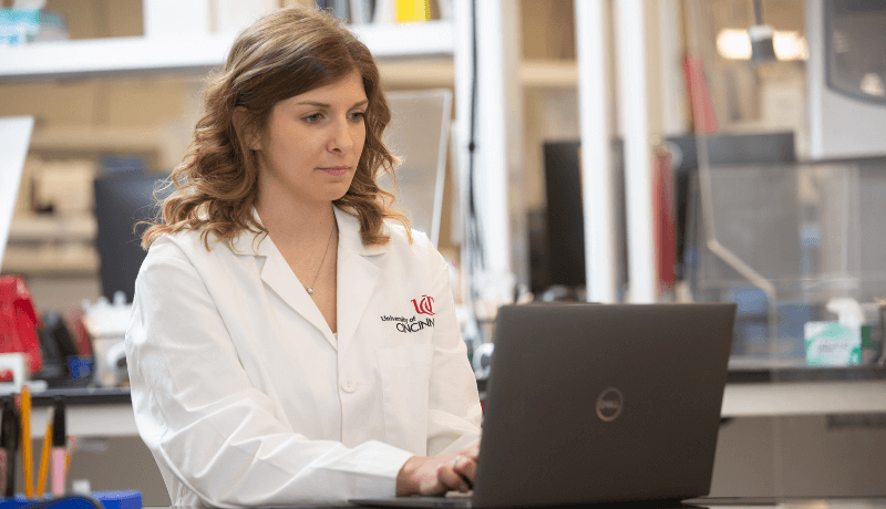 Female laboratory science student sitting behind a laptop