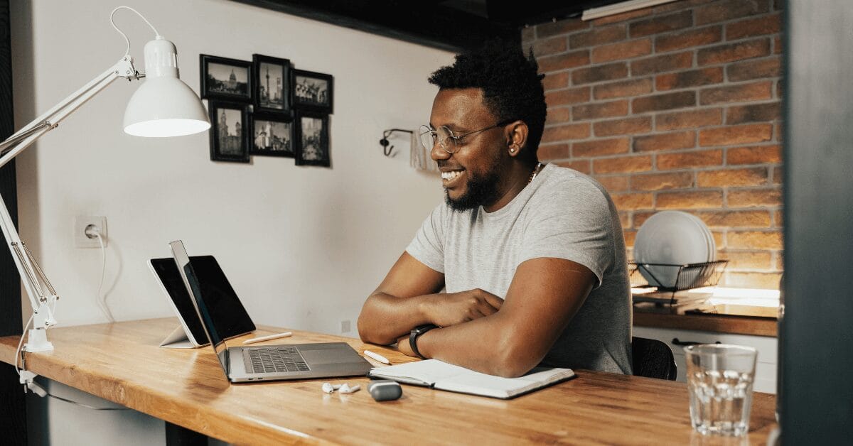 Student smiling while studying with a laptop