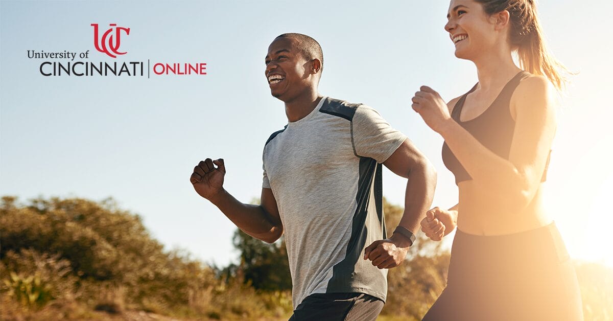 A man and woman run next to each other outside.